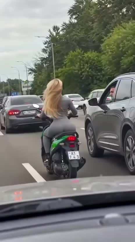 Afgeleid door een blondje op een scooter