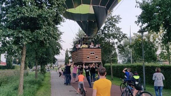Bewoners Nijkerk duwen luchtballon naar veilige plek om te landen