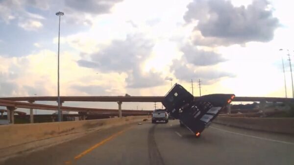 Vrachtwagen die té zwaar geladen is neemt een bocht en belandt op zijn kantje