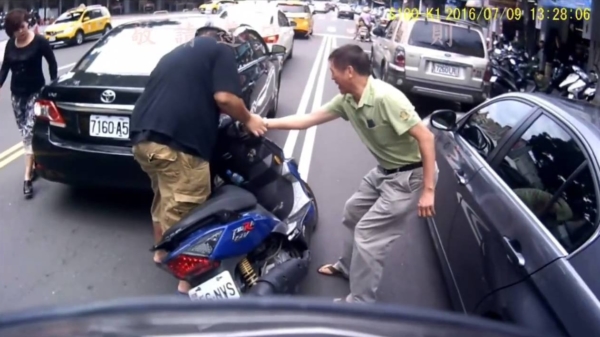 Onhandige automobilist probeert scooterrijder na ongelukje te helpen
