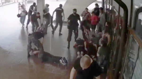 Voor de regen schuilende mensen uiteen gemept door oproerpolitie Wit-Rusland