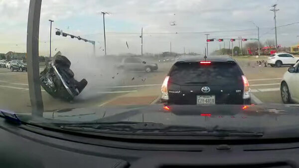 Gecrashte auto komt met een noodgang op z'n kop over de kruising glijden