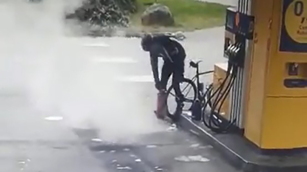 Snuggere wielrenner probeert zijn band op te pompen met een brandblusser