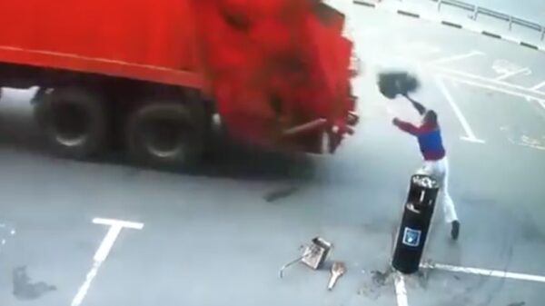 Oude doos: nog snel het afval in een vuilniswagen mikken