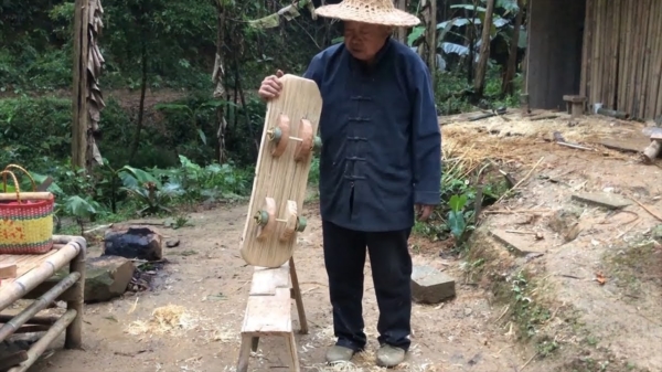 Chinese opa van het platteland maakt een skateboard van bamboe