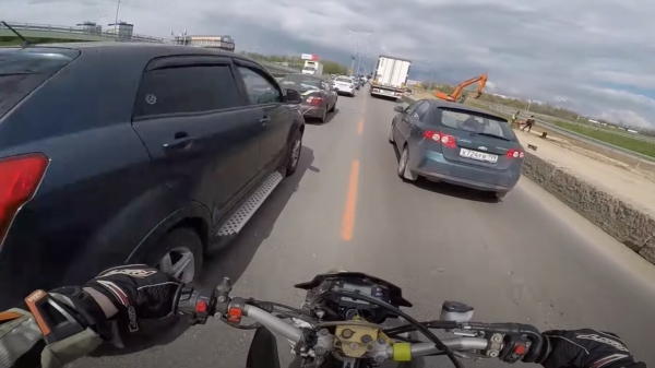 Wait for it: motorrijder slingert handig tussen het verkeer door en omzeilt zo de file