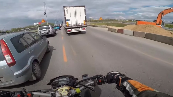 Wait for it: motorrijder slingert handig tussen het verkeer door en omzeilt zo de file