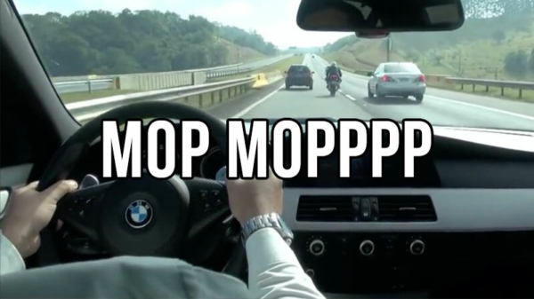 BMW M5 en motorrijder dagen elkaar uit en zigzaggen door het verkeer