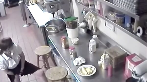 Serveerster bereidt knapperig worstje met extra veel zuurkool