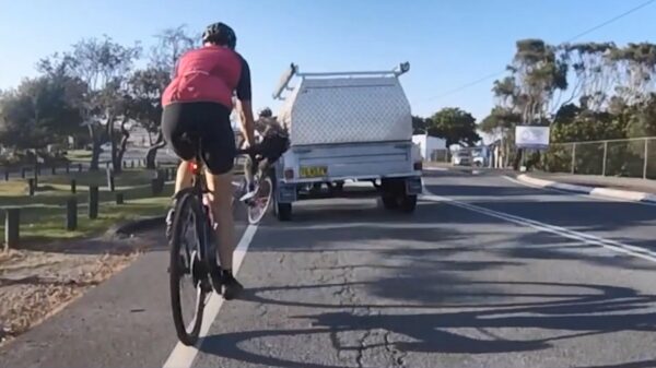 Wielrenner omver gekegeld door Stevie Wonder met een aanhanger