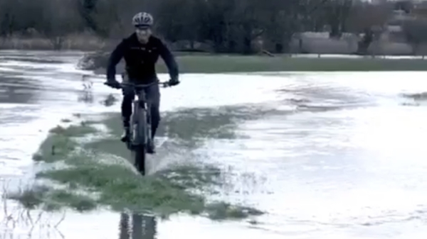 Sportieve fietser trotseert de overstroming en blijft keurig droog!