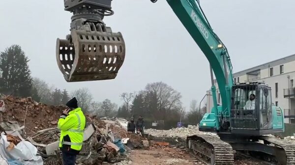 Lollige graafmachinist trekt muts van zijn collega's kopf af