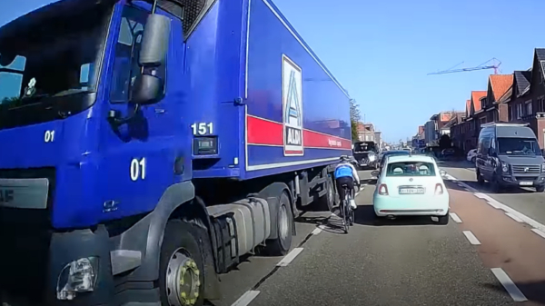 Belgische wielrenner heeft duidelijk extreme haast en kan net vrachtwagen ontwijken