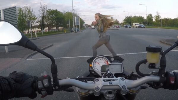 Oude doos: vriendelijke motorrijder laat voetganger weten dat ze op moet schieten