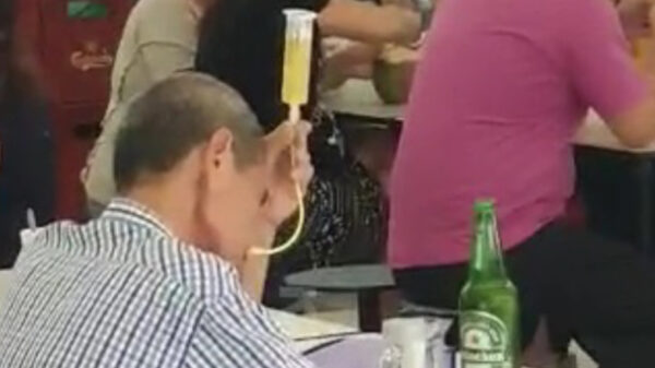 Bejaarde Aziaat besluit een lekker biertje te snuiven