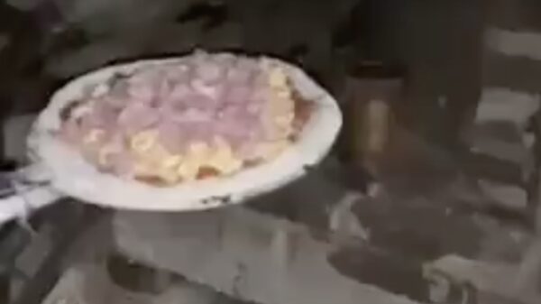 Zijn eerste zelfgemaakte pizza gaat eindelijk de oven in