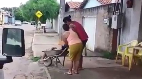 Braziliaanse vrouw brengt haar bezopen vent naar huis met de kruiwagen