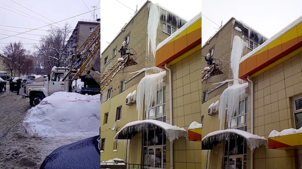 Russische werknemers verwijderen tactisch een ijspegel van het dak