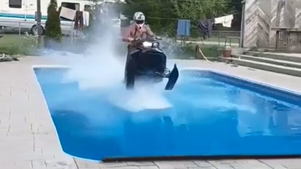 Droeftoeter op sneeuwscooter vlamt iets te hard over het zwembad