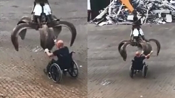 Rolstoeler wordt door hijskraan bij het oud ijzer gezet