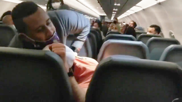 Vliegtuigpassagier grijpt stewardessen bij de boezem, wordt vastgezet met ducttape