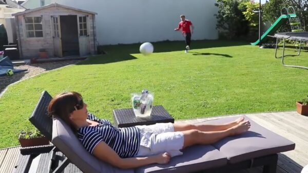 Kerel schiet met een voetbal zijn moeder vol op d'r blije bakkes