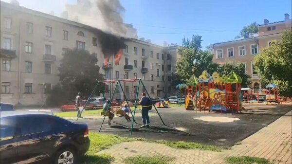 This is fine: lekker schommelen terwijl een appartementencomplex affikt