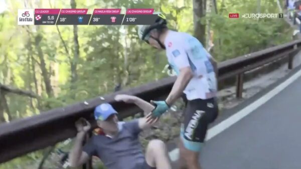 Miguel Lopez geeft mee rennende supporter die hem onderuithaalt een paar corrigerende tikken