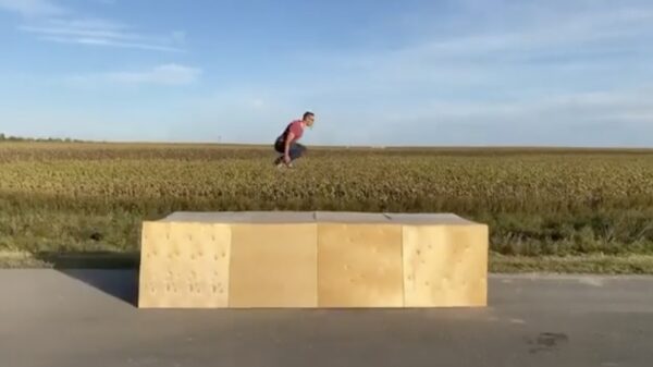 Stef Stuntpiloot springt van rijdende auto over een lading houten dozen