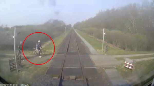 Wielrenners kunnen net op tijd remmen voor een aanstormde trein