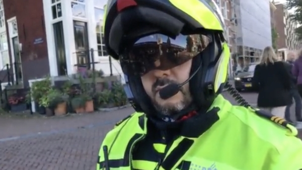BIJ1-activist Frank van der Linde staande gehouden voor megafoon met anti-PVV sticker