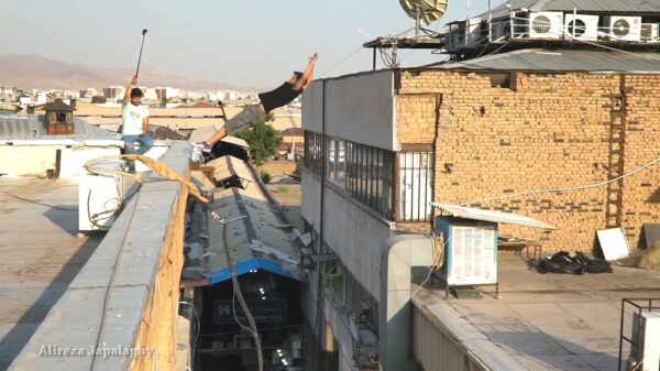 Parkourbaasje doet een front- en backflip tussen twee hoge gebouwen