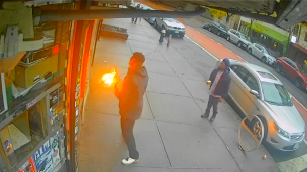 Ziek. Man knikkert molotovcocktail bij winkel in New York naar binnen