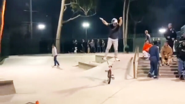 BMX-bink doet bovenop zijn stuur een rondje over het skatepark