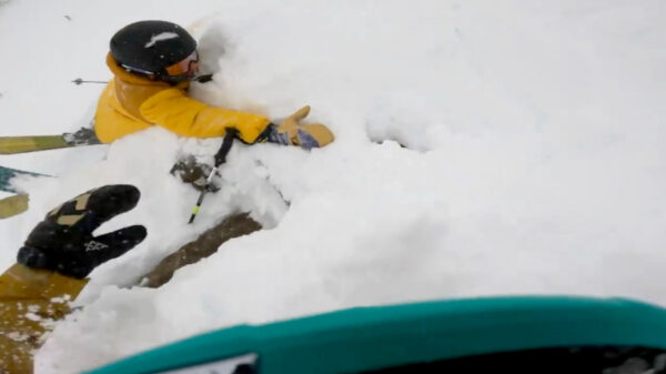 Skiër onder de sneeuw vandaan getrokken nadat hij een backflip van de berg maakt