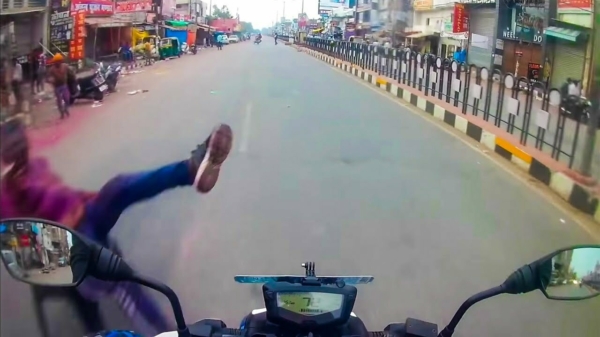 Kerel wordt in India midden op de weg doodleuk van zijn motor getrapt