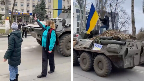 Man met cojones van staal klimt op Russisch voertuig en zwaait met de Oekraïense vlag