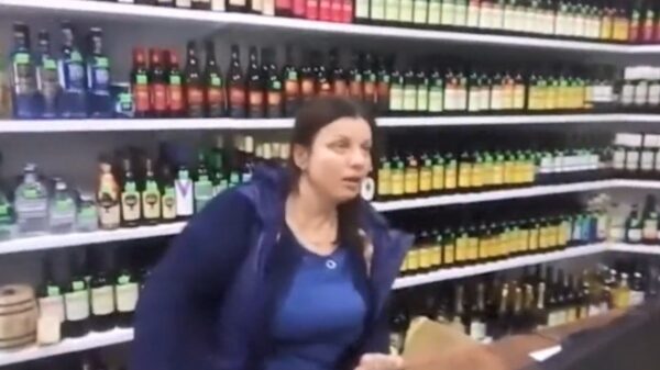 Russische medewerkster staat kacheltjelam achter de toonbank van een drankwinkel