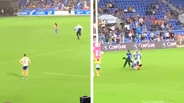 Vrouwelijke streaker wordt door beveiliger dubbelgevouwen nadat ze het veld op rent