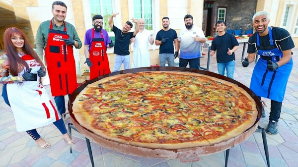 Blij ei Burak Özdemir maakt een reusachtige pizza