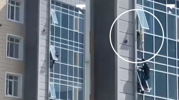 Held in Kazachstan redt kind dat op 7e verdieping uit het raam hangt