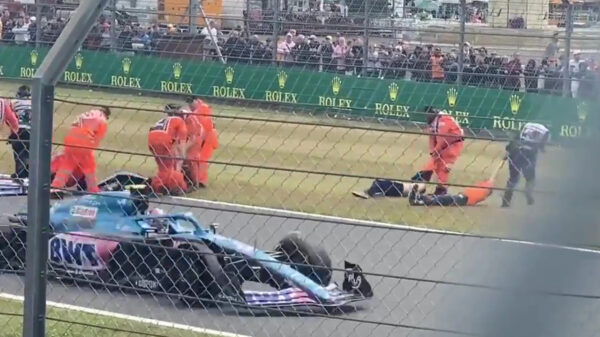 Demonstranten op het asfalt tijdens F1 in Silverstone, security sleept ze er hardhandig af