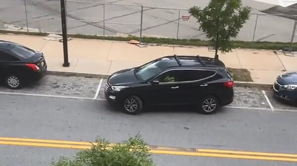 Vrouwelijke weggebruiker probeert haar slagschip op een kleine parkeerplaats te stallen