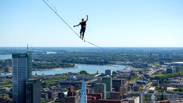 Koorddanser Jaan Roose maakt oversteek op 150 meter hoogte boven de Maas in Rotterdam