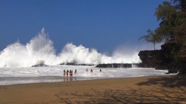 Gigantische golven bezorgen de strandgangers op Hawaï een hoop plezier