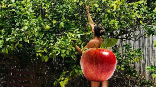 Doutzen geniet van een sappig appeltje in haar Eva-kostuum