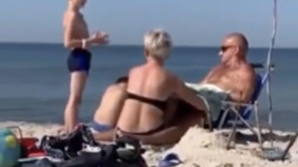 Vrouw poetst haar zonnebril op het strand