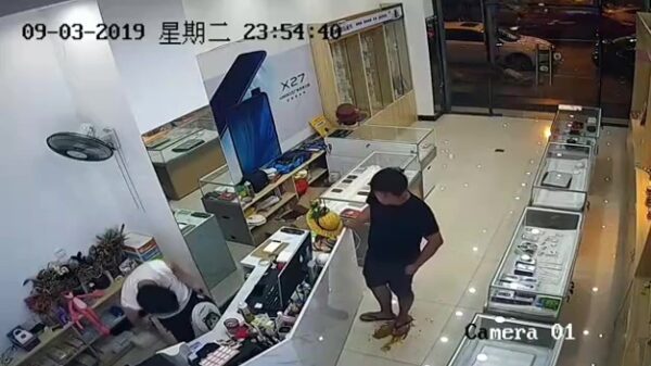 Smerige ransbak leegt zijn darmen terwijl 'ie in een winkel staat