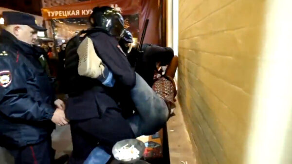 Russische demonstrant wordt hardhandig door de politie afgevoerd