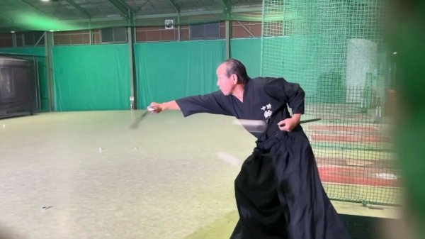 Mr. Miyagi slaat een honkbal op volle snelheid doormidden met zijn samurai-zwaard